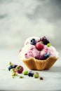 Pink ice cream with berries, strawberries, blueberries, raspberries, pistachios in waffle basket. Summer food concept Royalty Free Stock Photo