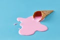 Pink ice cream melting and spilling from the waffle cone. Minimalistic summer food concept