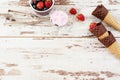 Pink Ice Cream served with berries - strawberries and blueberries in a yellow bowl. Waffle cones with chocolate. Light Rustic Wood Royalty Free Stock Photo