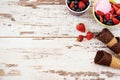 Pink Ice Cream served with berries - strawberries and blueberries in a yellow bowl. Waffle cones with chocolate. Light Rustic Wood Royalty Free Stock Photo