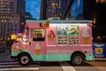 Pink ice cream truck on a street in New York at dusk