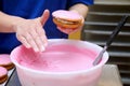 pink icing being applied by hand