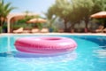 Pink inflatable ring floating in a sunny resort pool