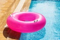 Pink Inflatable ring floating in swimming pool. Refreshing blue water. Summer travel hotel vacation Royalty Free Stock Photo