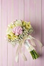 Pink and ivory wedding bouquet on pink wooden background, gift for holidays and celebration