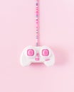 .Pink joystick with colorful cable on soft pastel pink background. Minimalistic flat lay