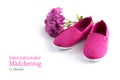 Pink kid shoes and a flower isolated on a white background, german text Internationaler Maedchentag 11 October, that means