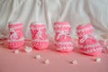 Pink knitted booties on pink background with marshmallow hearts Royalty Free Stock Photo