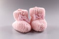 Pink knitted slippers for newborn on gray background Royalty Free Stock Photo