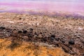 Pink lake, textures pictured from above. Close up picture. Sand, rocks, stones, pink water. Color pink due to salty water and