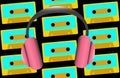 Pink large full-sized headphones for listening to music on the background of old retro vintage hipster audio cassettes from the 80 Royalty Free Stock Photo