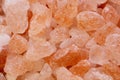 Pink large Himalayan salt in a glass bowl and a wooden spoon is scattered on the table