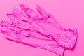 Pink latex gloves to protect against viruses and bacteria. Pink background.