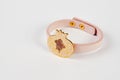 Pink leather and gold cuff bracelet on white background with copy space
