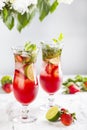 Pink lemonade with strawberries, lime, basil and mint
