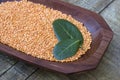 Pink lentil on wooden platter over rustic wooden table