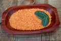 Pink lentil on wooden platter over rustic wooden table