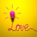 A pink light bulb and a wire laid out in the LOVE word on a bright yellow background. Royalty Free Stock Photo