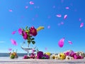 pink lilac yellow white  and  wild rose hip  meadow flowers  in glass  on wooden bench  at sea , summer beach blue sky flying pe Royalty Free Stock Photo