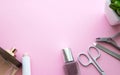 Pink lipstick, nail polish, pink color, perfume bottle, manicure scissors, nail file, cuticle nippers and petite flower in a white