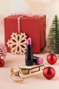 Pink lipstick on a wooden sled on a New Year's background. Stylish Christmas lipstick advertisement.