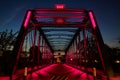 Pink-Lit Truss Bridge at Blue Hour, Wooden Deck Perspective