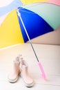 Pink little children rubber boots stand under colorful umbrella Royalty Free Stock Photo