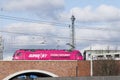 Pink locomotive on a bridge over a highway in front of the Funkturm Radio Tower Berlin