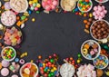 Pink lollipop candies in jar with various milk chocolate and jelly gums candies on black background with liquorice allsorts and Royalty Free Stock Photo