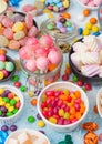 Pink lollipop candies in jar with various milk chocolate and jelly gums candies on blue background with liquorice allsorts and Royalty Free Stock Photo