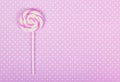 Pink lollipop. Pink paper background. Pink polka dot background.