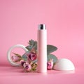 Pink lotion bottle or aroma fragrance bottle with pink flowers on pink background