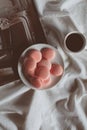 Pink macaron cookies with cup of coffee and rose flowers on white background. Royalty Free Stock Photo