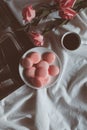 Pink macaron cookies with cup of coffee and rose flowers on white background. Royalty Free Stock Photo