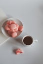 Pink macaron cookies with cup of coffee and rose flowers on white background. Royalty Free Stock Photo