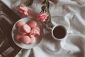 Pink macaron cookies with cup of coffee and rose flowers on white background. Royalty Free Stock Photo