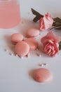 Pink macaroons with bouquet of rose on marble table, pastel colored, Royalty Free Stock Photo