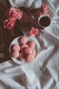 Pink macaroons with coffee cup and pink rose in vintage tone. Royalty Free Stock Photo