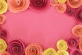 Pink, magenta and yellow paper rose flat lay background with flowers around the endges and empty copy space in middle Royalty Free Stock Photo