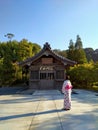 Pink Maiden in front of one of Dazaifu& x27;s temple