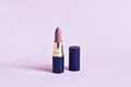 Pink matte lipsticks holdings on a white stand on a pink background. Beauty industry product concept. Glamorous makeup accessory c