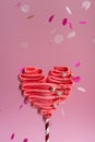 Pink meringue heart on a stick. Pink background, sweets for lovers. Meringue handmade