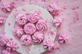 Pink meringues on plate, colorful background