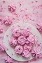 Pink meringues on plate, colorful background