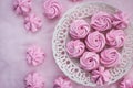 Pink meringues on plate, colorful background