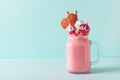 Pink milkshake with cream, marshmallow candy hearts on blue background Royalty Free Stock Photo