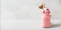 Pink milkshake with cream, marshmallow candy hearts on white background Royalty Free Stock Photo