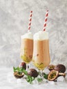 Pink milkshake with ice cubes and mint leaves and fruits of passion fruit on a marble table, selective focus Royalty Free Stock Photo