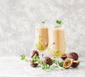 Pink milkshake with ice cubes and mint leaves and fruits of passion fruit on a marble table, selective focus Royalty Free Stock Photo