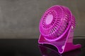 Pink mini fan working on black table Royalty Free Stock Photo